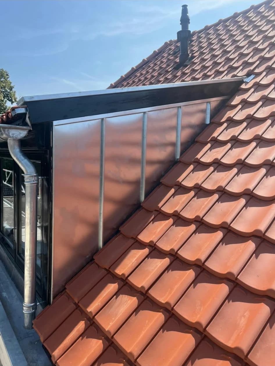 Rood pannendak met zinken dakkapelafwerking